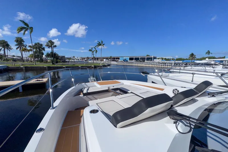 Trade In Yacht Photos Pics 2022 Jeanneau Leader 12.5 WA yacht docked in a sunny marina with palm trees.