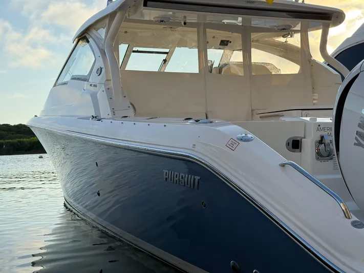  Yacht Photos Pics 2022 Pursuit DC 365 Dual Console boat on calm water at sunset.