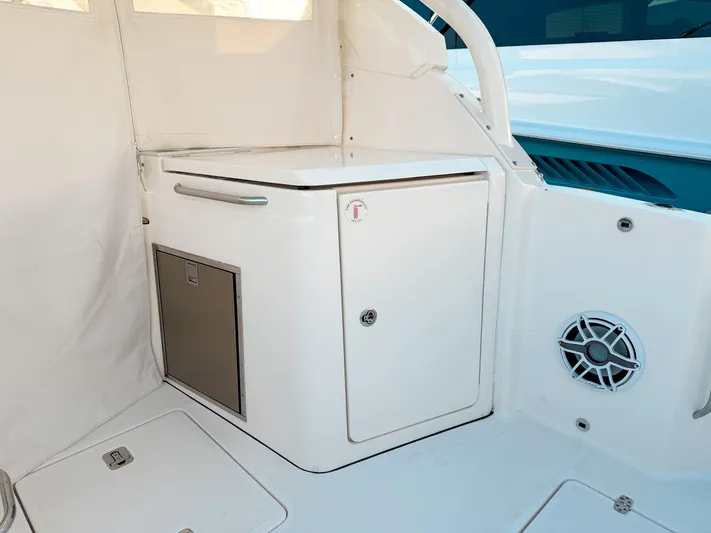  Yacht Photos Pics 2022 Pursuit DC 365 Dual Console interior with storage compartment and speaker.
