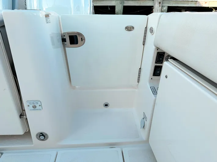  Yacht Photos Pics 2022 Pursuit DC 365 Dual Console boat interior, featuring a white access door and seating area.