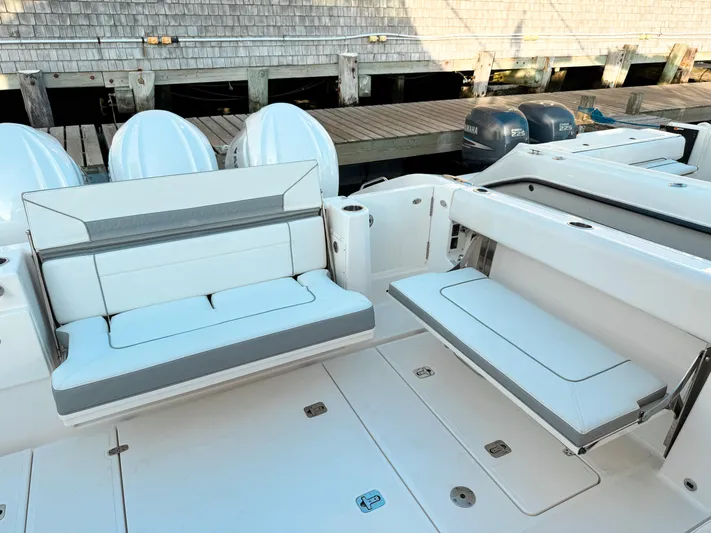  Yacht Photos Pics 2022 Pursuit DC 365 Dual Console boat with white seating and docked engines.