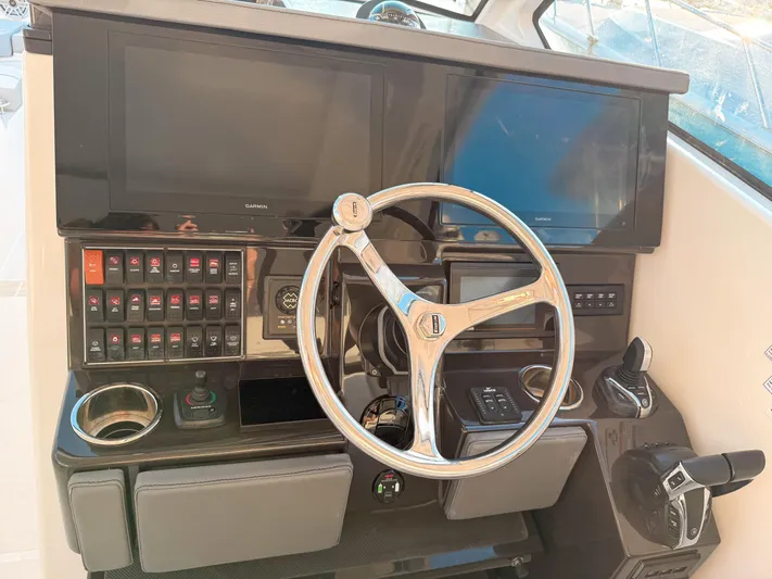 Yacht Photos Pics 2022 Pursuit DC 365 Dual Console helm with steering wheel and control panel.