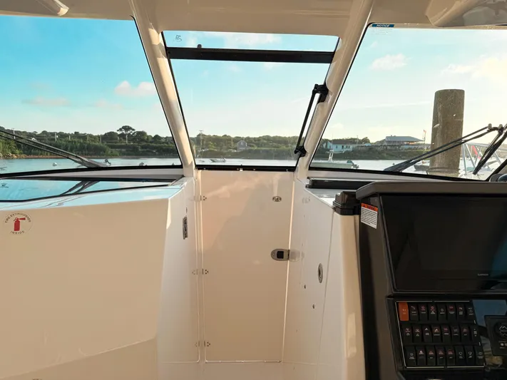  Yacht Photos Pics 2022 Pursuit DC 365 Dual Console boat interior with dashboard and scenic water view.