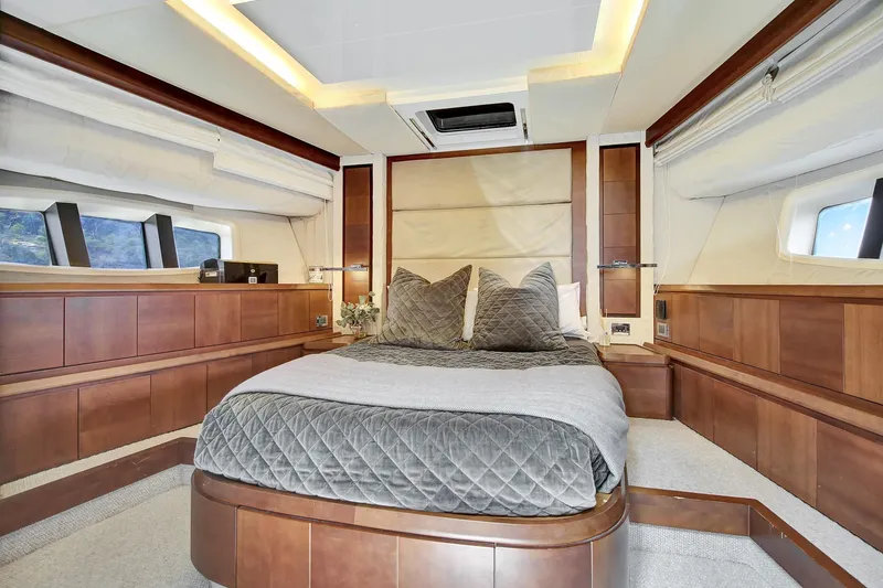  Yacht Photos Pics Luxurious bedroom interior of a 2006 Azimut 75 yacht with elegant wood finishes.