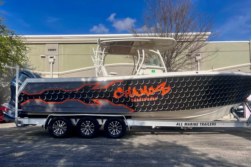  Yacht Photos Pics 2016 Sailfish 290 CC boat on trailer with custom graphics, parked outdoors.