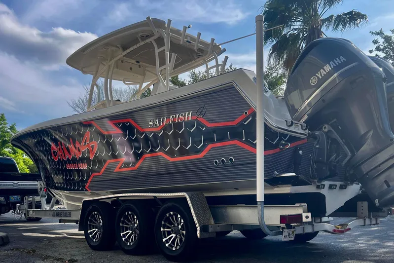  Yacht Photos Pics 2016 Sailfish 290 CC boat on trailer with Yamaha engines, parked under a cloudy sky.