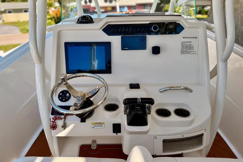  Yacht Photos Pics 2016 Sailfish 290 CC boat dashboard with steering wheel, controls, and navigation display.