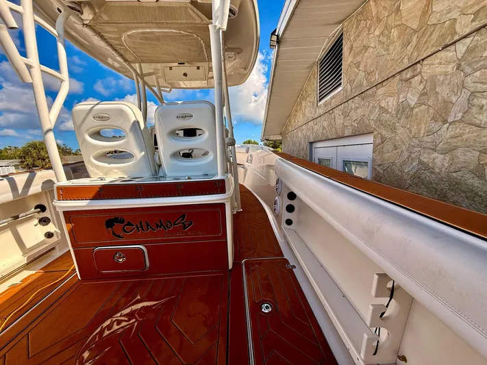  Yacht Photos Pics 2016 Sailfish 290 CC boat interior with seating and storage, docked beside a stone building.