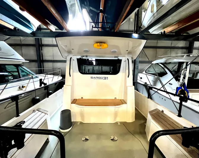 Sisu Yacht Photos Pics 2020 Sargo 31 boat interior, docked in a marina, showcasing seating and storage areas.