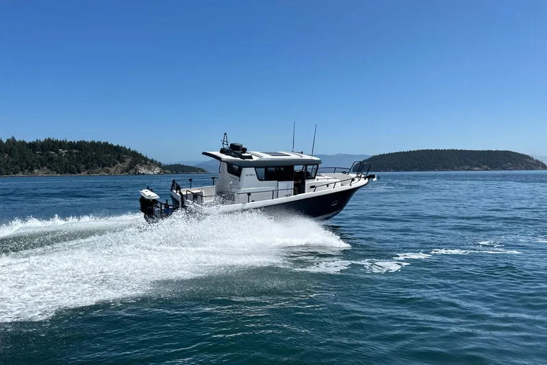 Sisu Yacht Photos Pics 2020 Sargo 31 boat cruising on open water with scenic island background.