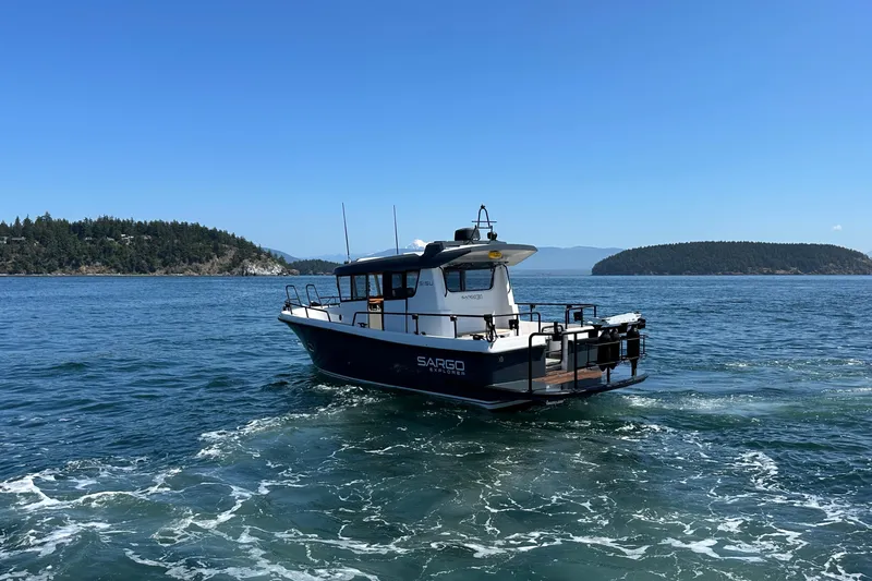 Sisu Yacht Photos Pics 2020 Sargo 31 boat cruising on a scenic lake with islands in the background.