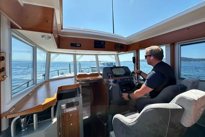 Sisu Yacht Photos Pics Man steering 2020 Sargo 31 boat on open water.