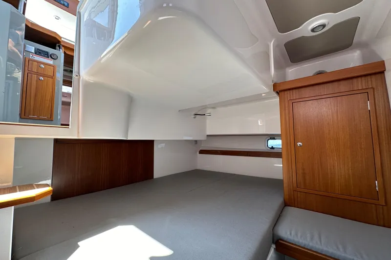 Sisu Yacht Photos Pics Interior cabin of 2020 Sargo 31 boat with wooden cabinetry and grey bedding.