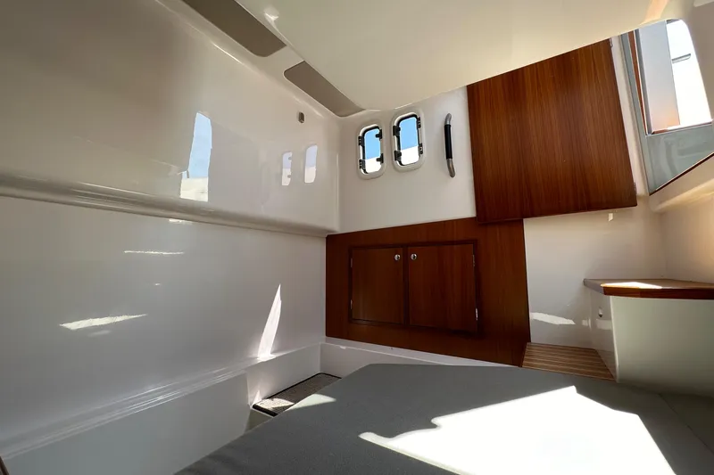 Sisu Yacht Photos Pics Interior cabin of 2020 Sargo 31 boat with wooden cabinets and porthole windows.