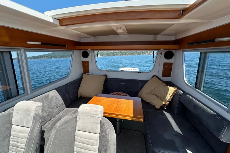 Sisu Yacht Photos Pics Interior of 2020 Sargo 31 boat with seating area and table, overlooking the water.
