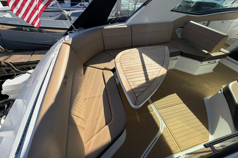 Sea Jay Yacht Photos Pics 2023 Sea Ray Sundancer 320 Outboard interior with tan seating and wooden table.