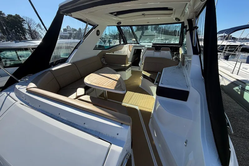 Sea Jay Yacht Photos Pics 2023 Sea Ray Sundancer 320 Outboard interior with seating and table, docked at marina.