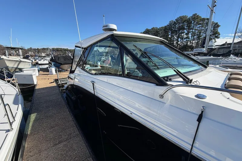 Sea Jay Yacht Photos Pics 2023 Sea Ray Sundancer 320 Outboard docked at marina under clear blue sky.
