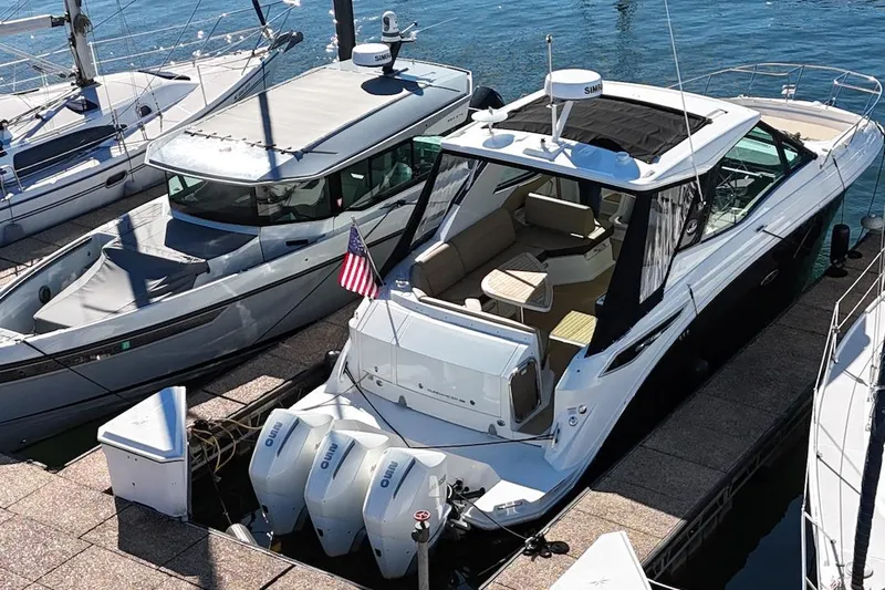 Sea Jay Yacht Photos Pics 2023 Sea Ray Sundancer 320 Outboard docked, featuring spacious seating and triple outboard engines.