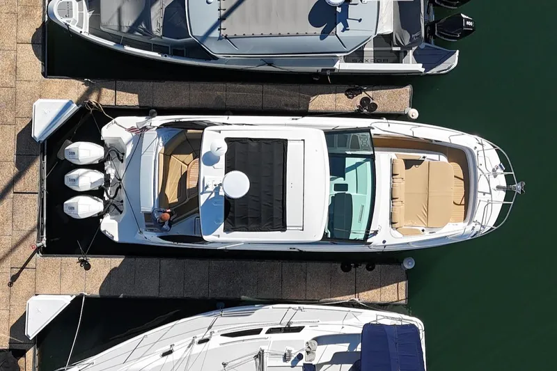 Sea Jay Yacht Photos Pics 2023 Sea Ray Sundancer 320 Outboard docked, aerial view, showcasing sleek design and spacious layout.