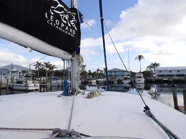  Yacht Photos Pics Leopard 48 catamaran docked at marina, 2014 model, with palm trees and boats in background.