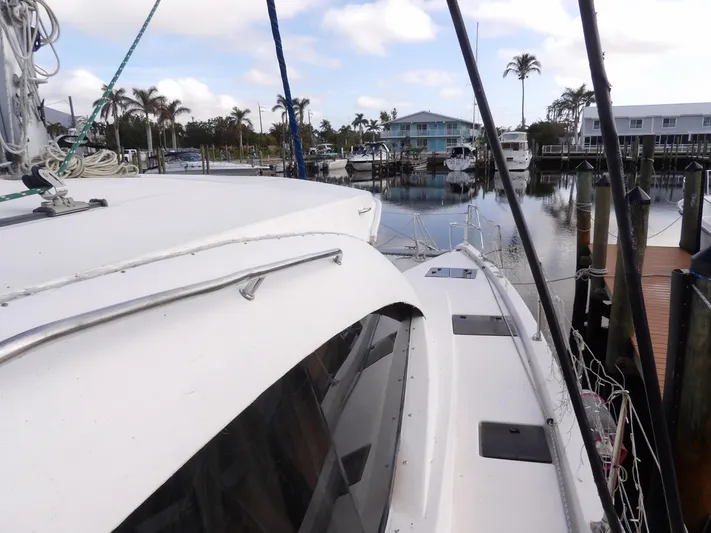 Yacht Photos Pics Leopard 48 catamaran docked in marina, 2014 model, with palm trees and waterfront homes.