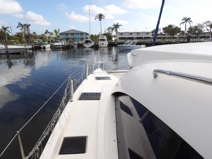  Yacht Photos Pics Leopard 48 yacht docked in a marina, 2014 model, with calm water and palm trees.