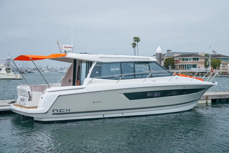 Dark Side Yacht Photos Pics 2017 Jeanneau NC11 boat docked in a marina, featuring sleek design and modern amenities.