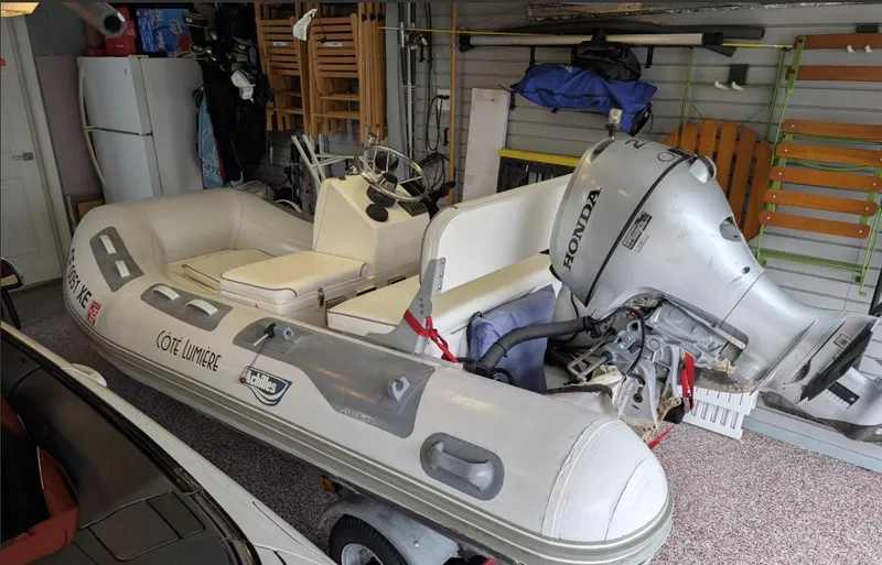 Dark Side Yacht Photos Pics Inflatable boat with Honda outboard motor stored in a garage.