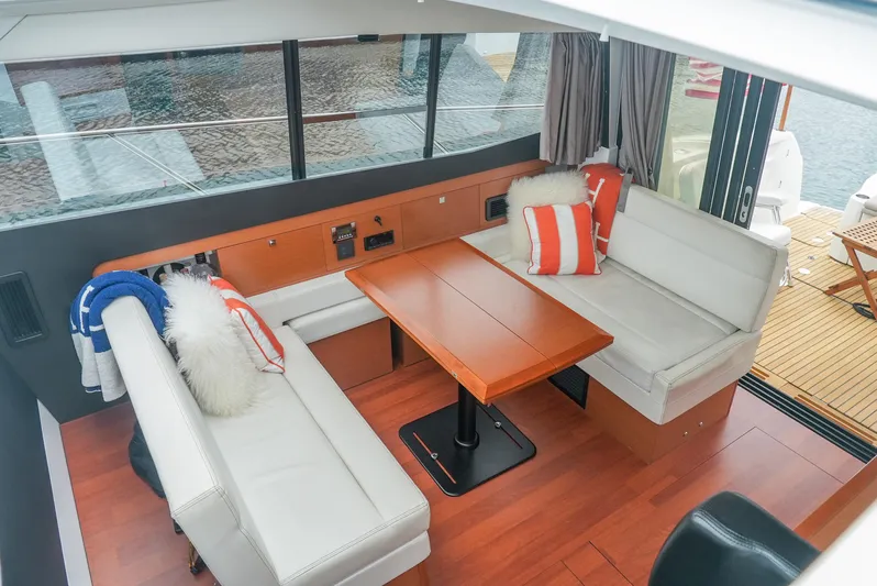 Dark Side Yacht Photos Pics 2017 Jeanneau NC11 interior with cozy seating, wooden table, and nautical decor.