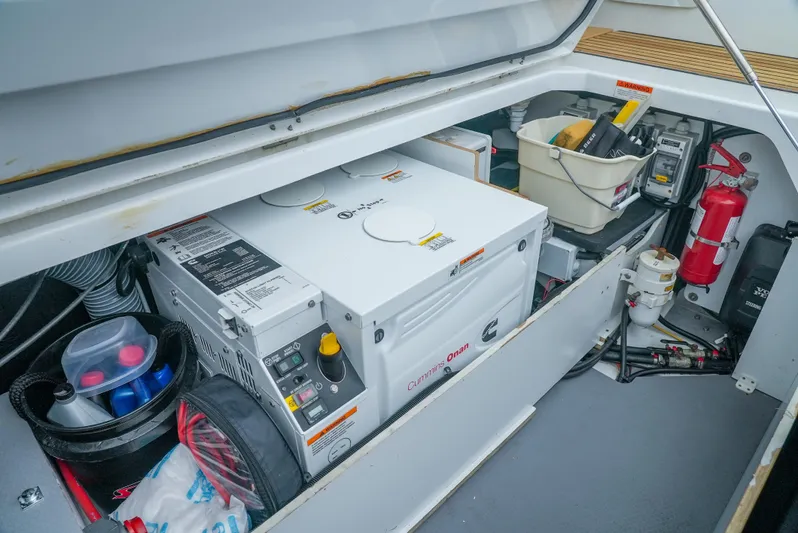 Dark Side Yacht Photos Pics Engine compartment of a 2017 Jeanneau NC11 boat, featuring a generator and safety equipment.