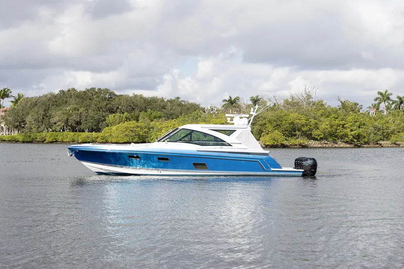 Andrea Christine Yacht Photos Pics 2019 Formula 430 Super Sport Crossover boat on calm water, surrounded by lush greenery.