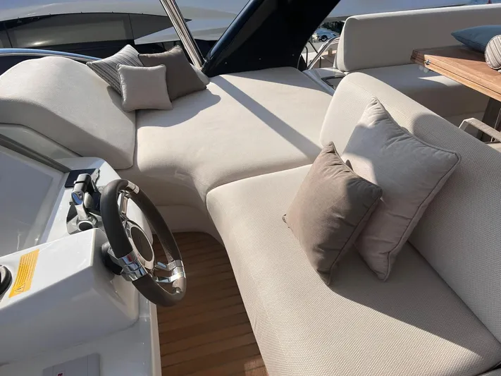 Ns03445 Yacht Photos Pics Luxurious seating area on 2022 Lagoon SIXTY 7 yacht with plush cushions and steering wheel.