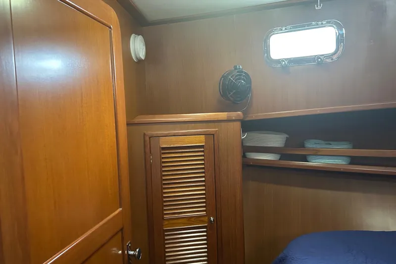  Yacht Photos Pics 2006 Mariner Orient cabin interior with wooden paneling, shelves, and porthole window.