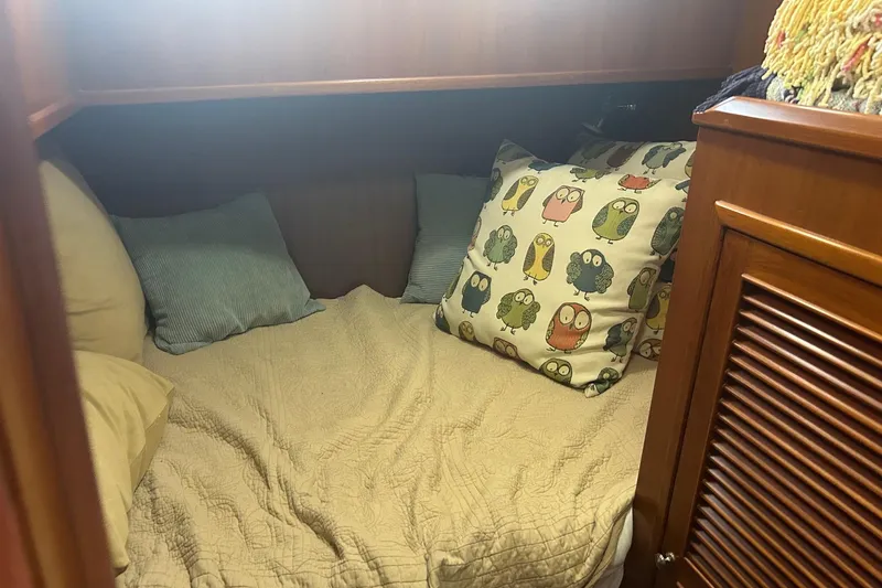  Yacht Photos Pics Cozy cabin bed in 2006 Mariner Orient with owl-themed pillows and wooden cabinetry.