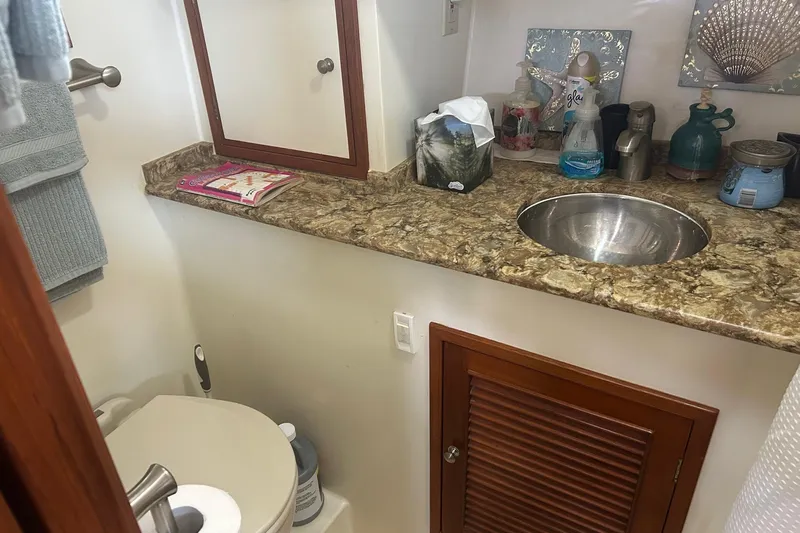  Yacht Photos Pics Compact bathroom in a 2006 Mariner Orient boat with granite countertop and stainless steel sink.