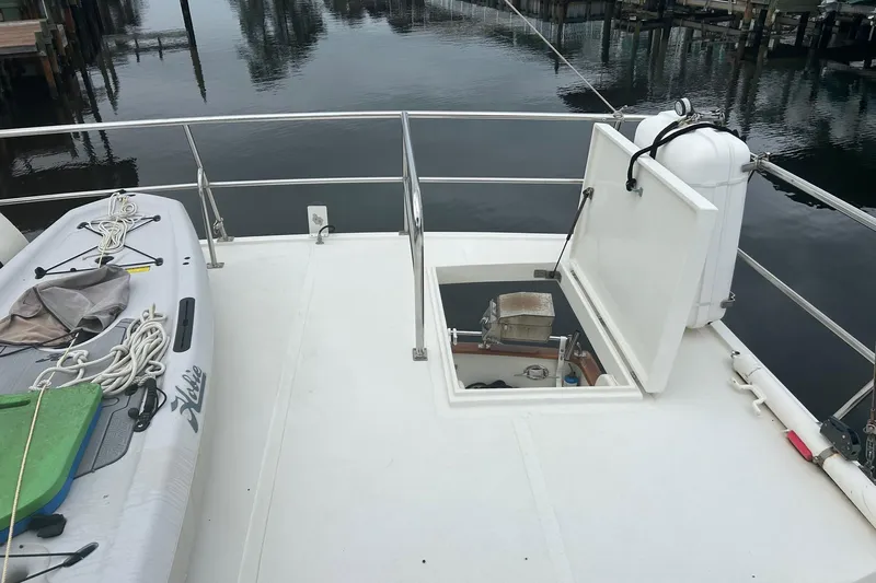  Yacht Photos Pics 2006 Mariner Orient yacht deck with open hatch and kayak, docked by calm water.