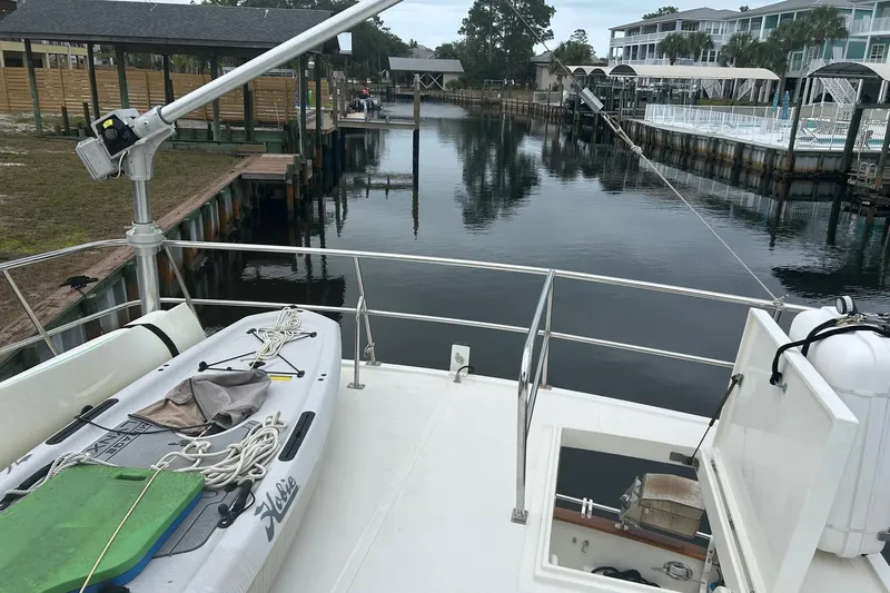  Yacht Photos Pics 2006 Mariner Orient boat docked, featuring a paddleboard and calm waterfront view.