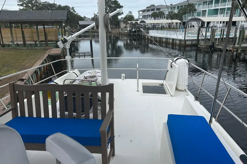  Yacht Photos Pics 2006 Mariner Orient boat deck with blue seating, docked near waterfront buildings.