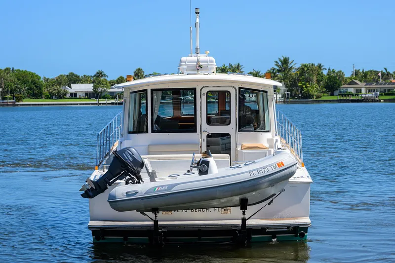Seabird Yacht Photos Pics 2014 Grand Banks 46 Eastbay SX yacht with dinghy on calm water.