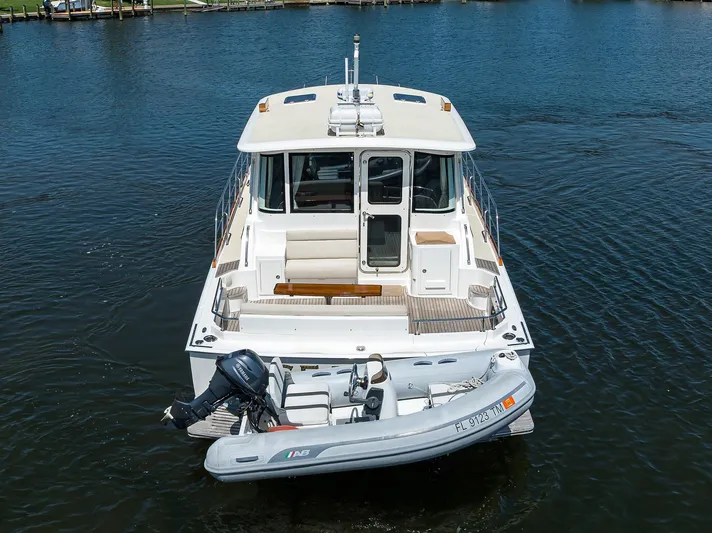 Seabird Yacht Photos Pics 2014 Grand Banks 46 Eastbay SX yacht with dinghy on calm water.