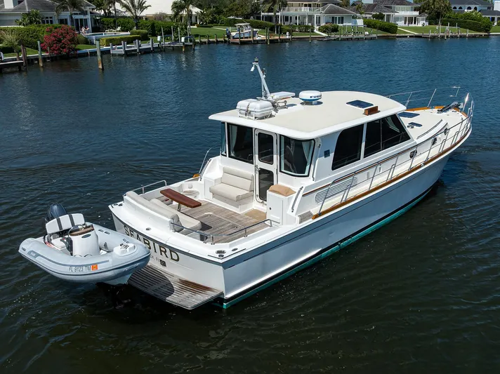 Seabird Yacht Photos Pics 2014 Grand Banks 46 Eastbay SX yacht on calm water, featuring a small attached dinghy.