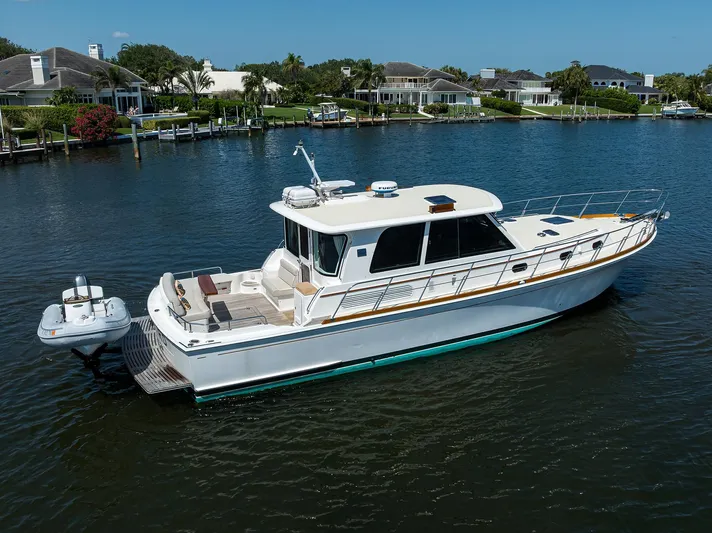 Seabird Yacht Photos Pics 2014 Grand Banks 46 Eastbay SX yacht on calm water near waterfront homes.