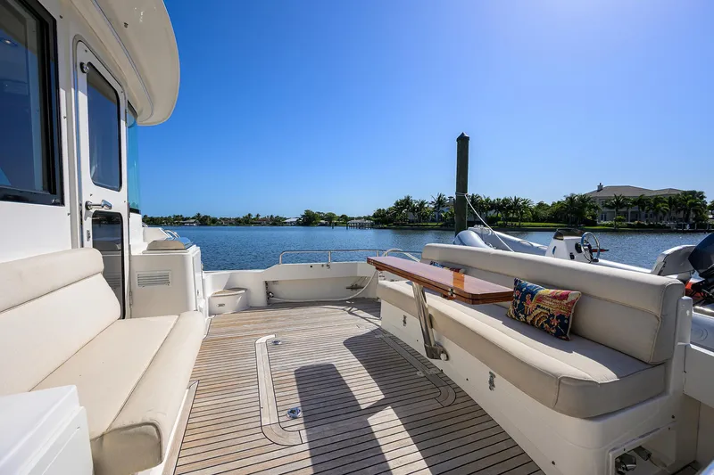 Seabird Yacht Photos Pics 2014 Grand Banks 46 Eastbay SX yacht deck with seating, table, and scenic water view.