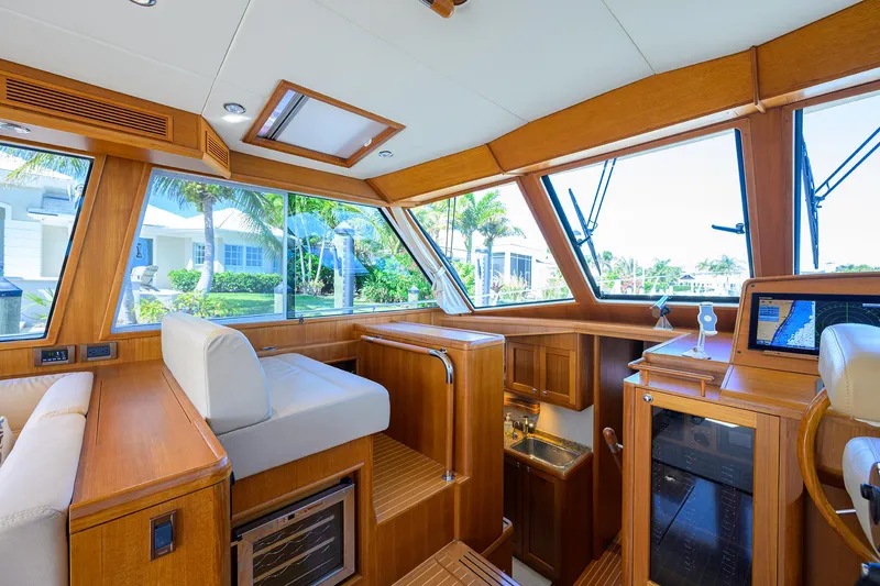 Seabird Yacht Photos Pics Luxurious interior of 2014 Grand Banks 46 Eastbay SX yacht with wooden finishes and large windows.