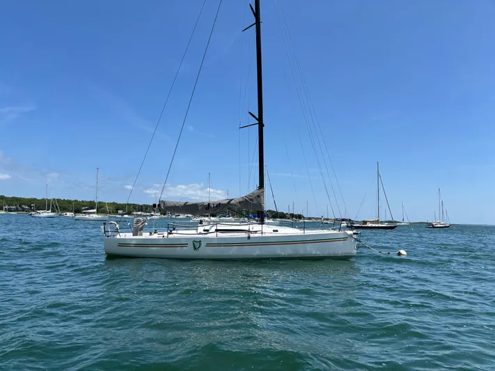 Ceilidh Yacht Photos Pics 2018 J Boats J/121 sailboat anchored in a scenic harbor under a clear blue sky.