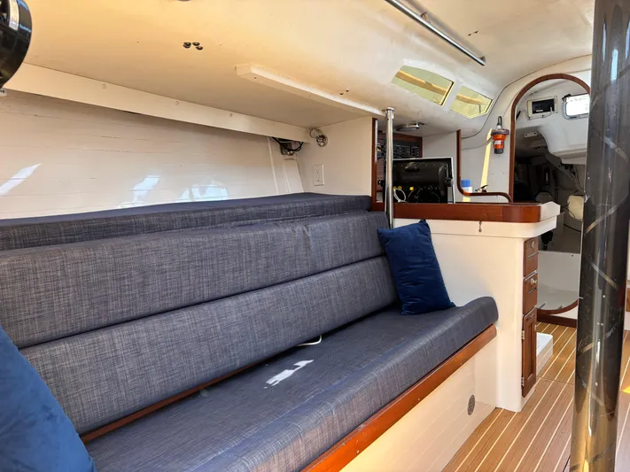Ceilidh Yacht Photos Pics Interior of 2018 J Boats J/121 sailboat with blue seating and wooden accents.