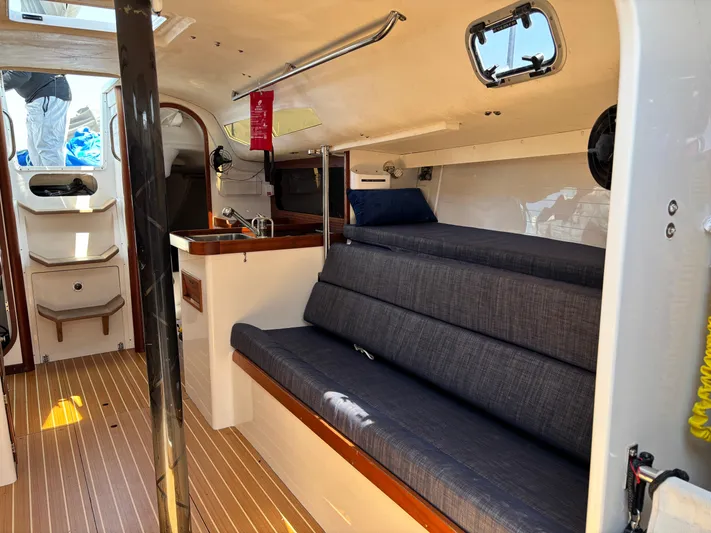 Ceilidh Yacht Photos Pics Interior of 2018 J Boats J/121 sailboat with seating and compact kitchen area.