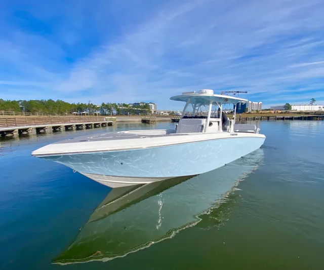  Yacht Photos Pics 2022 Fountain 34 Tournament Edition boat on calm water near a dock.