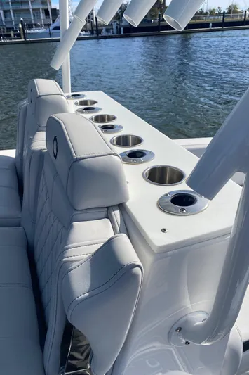  Yacht Photos Pics 2022 Fountain 34 Tournament Edition boat with rod holders and cup holders by the water.